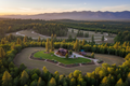 Aerial view of well-maintained defensible space around a forest property with clear fuel breaks and golden sunset over Sierra Nevada mountains