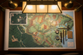 Professional forest management map spread on a table with aerial photography of forested land and forestry tools beside it